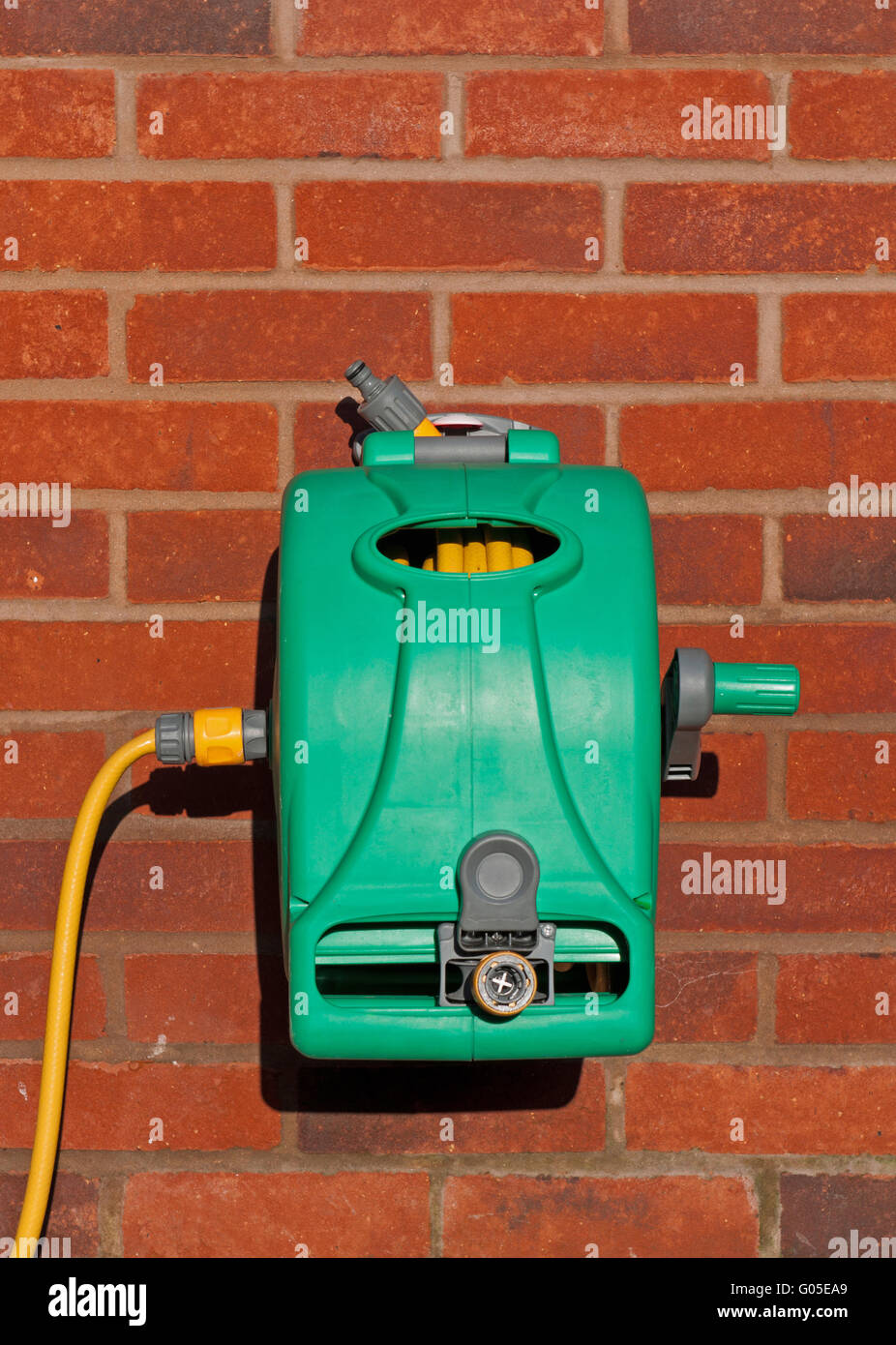 garden hose reel kit installed on a brick wall (copyspace available