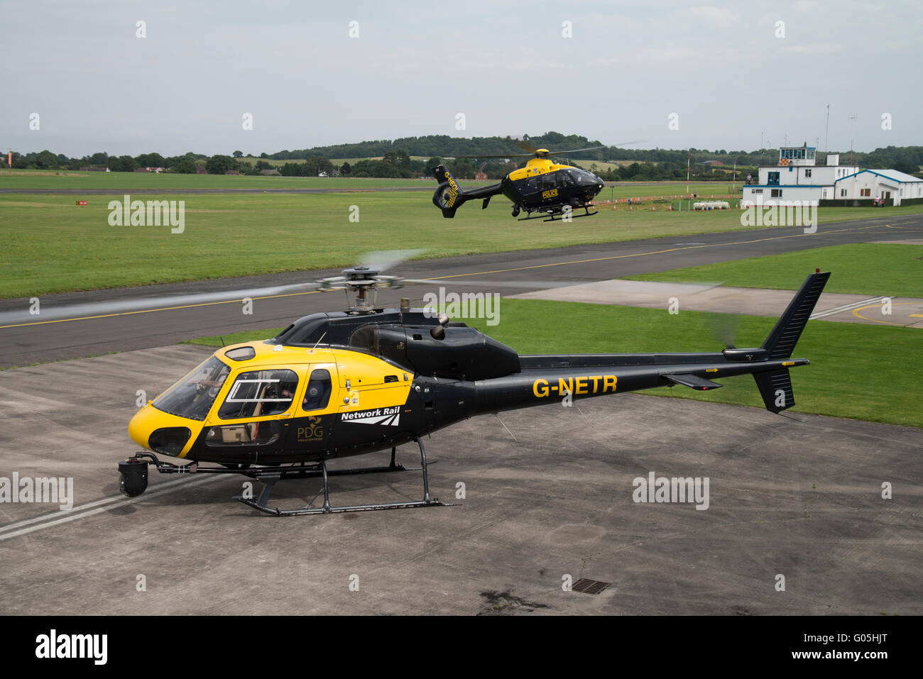 Wolverhampton Airport. Network Rail AS355 helicopter in the foreground with police EC135 landing behind. Stock Photo