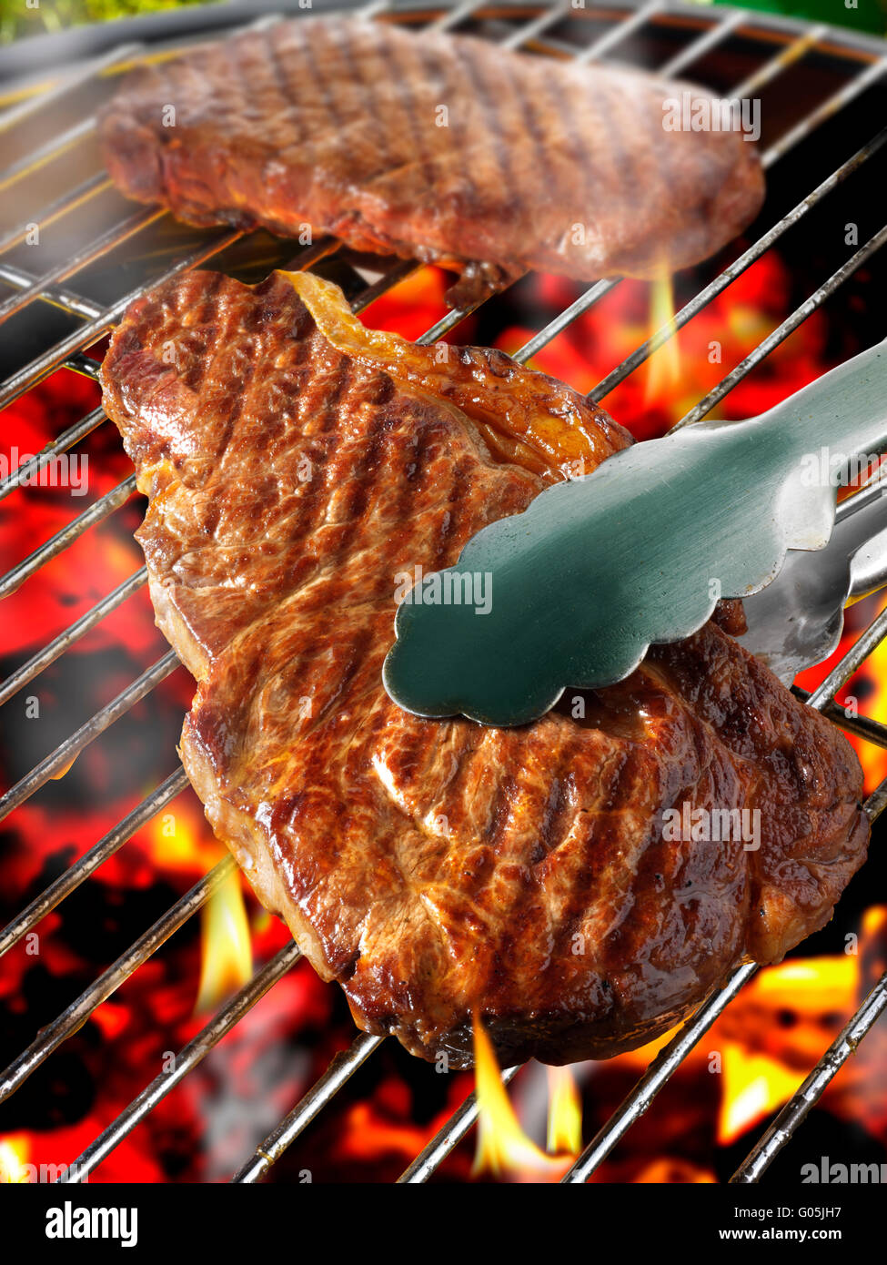 Barbecue steak cooking on a flame bbq grill Stock Photo