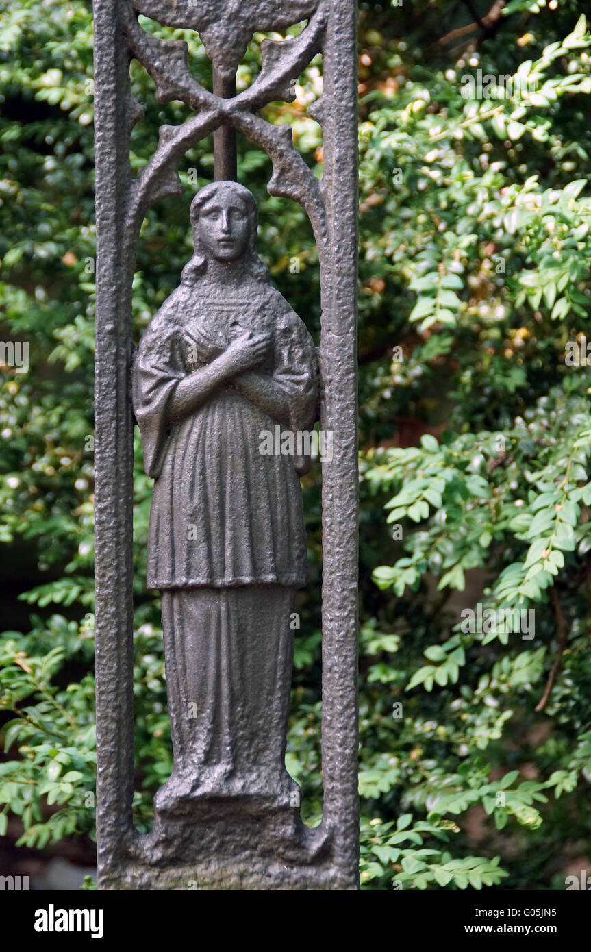 Grieving Madonna at the foot of an ancient iron cr Stock Photo