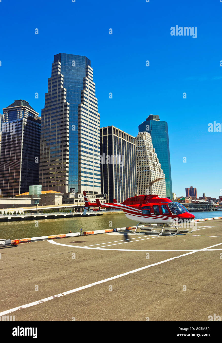 Helicopter landing on helipad in Lower Manhattan New York, USA, on East River. Pier 6. Skyscrapers on the background Stock Photo