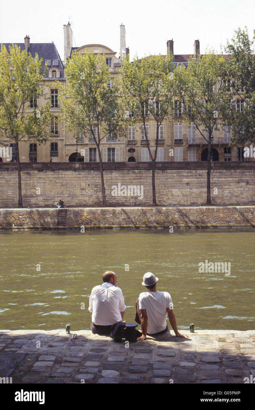 Men sitting on the banks of the Seine Stock Photo