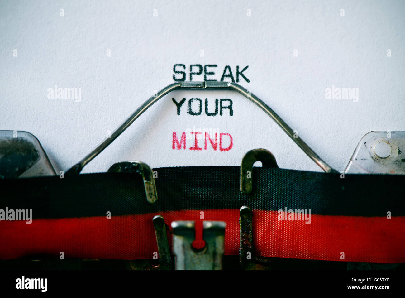 closeup of an old typewriter and the text speak your mind typewritten with it in a foil, with a vignette added Stock Photo