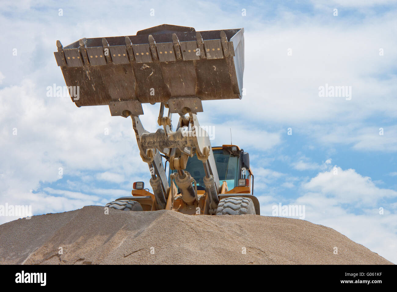 Yellow excavator on a construction site against blue sky Stock Photo ...