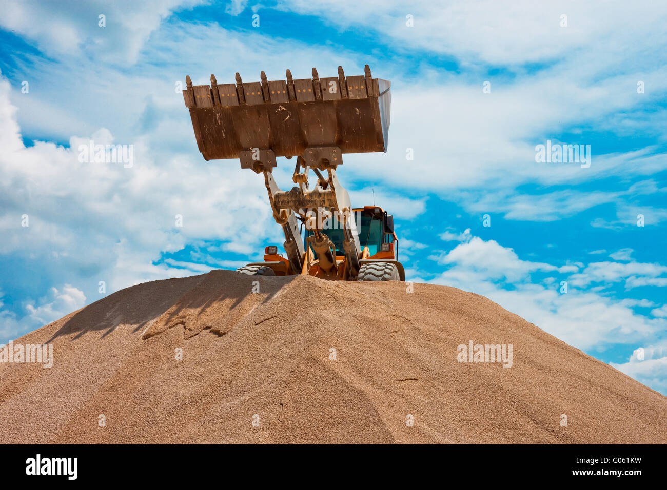Yellow excavator on a construction site against blue sky Stock Photo ...