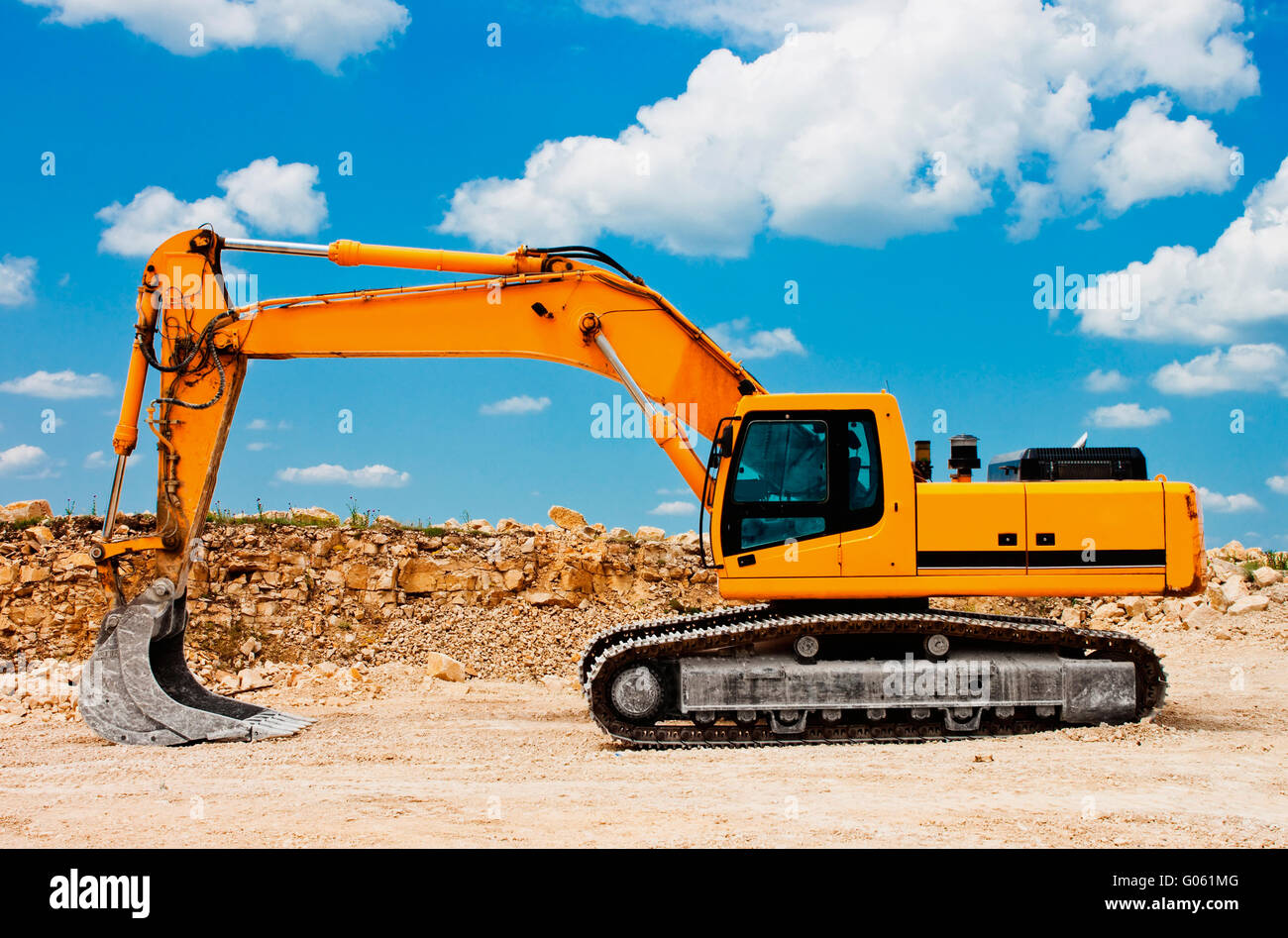 Yellow excavator on a construction site against blue sky Stock Photo ...