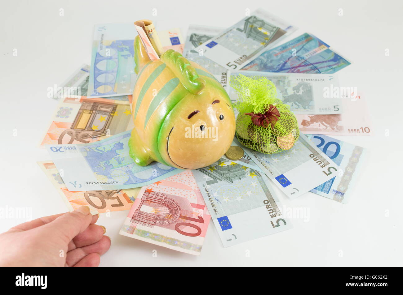 Toy fish piggy bank on top of euro bills Stock Photo