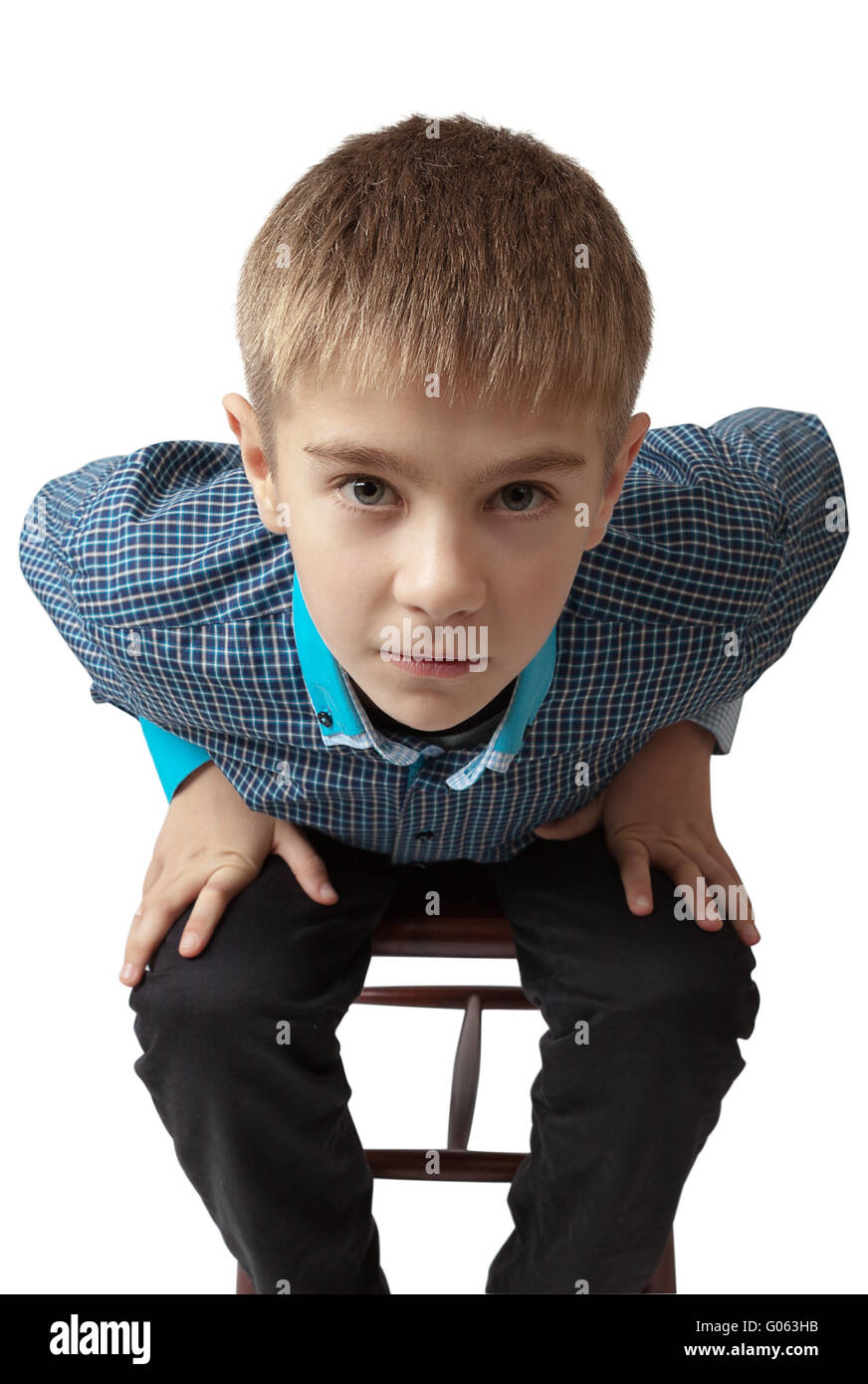 surprised boy sitting on a chair isolated on white Stock Photo