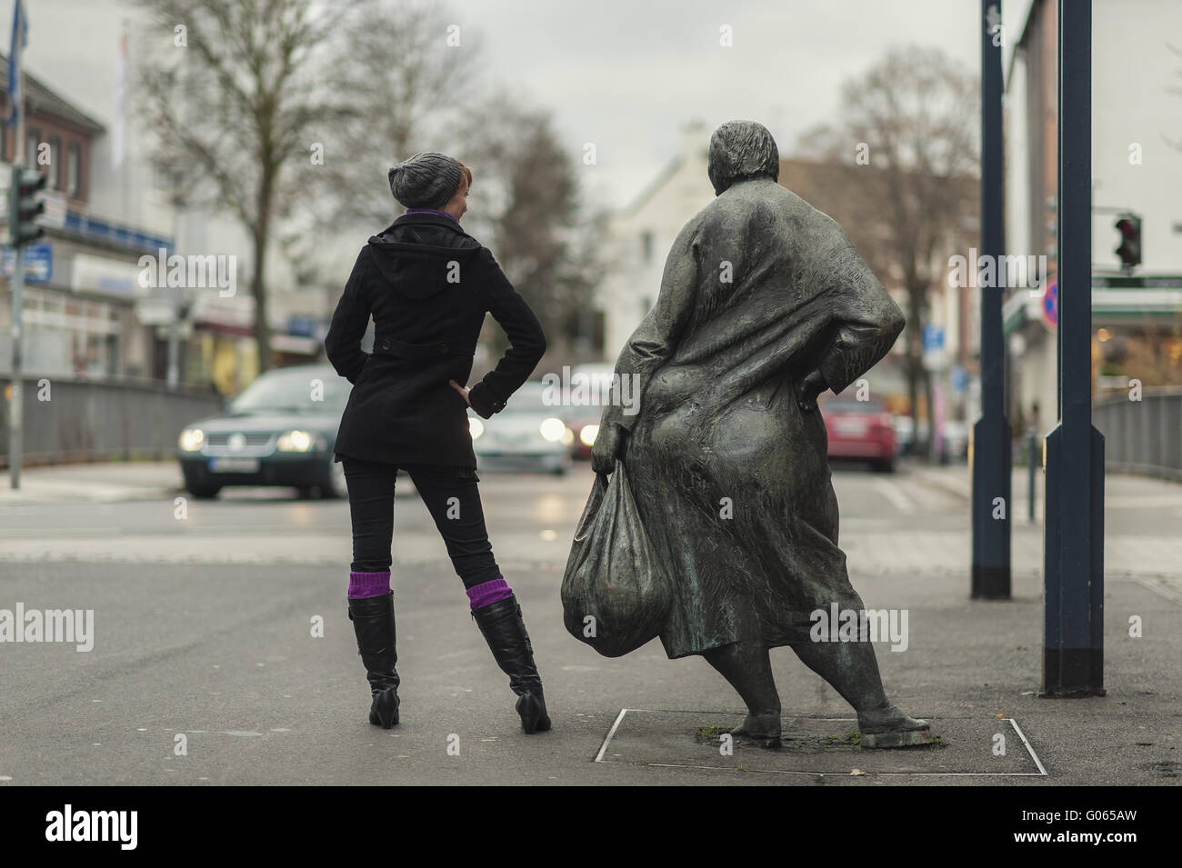 young woman and statue in the pedestrian zone Stock Photo