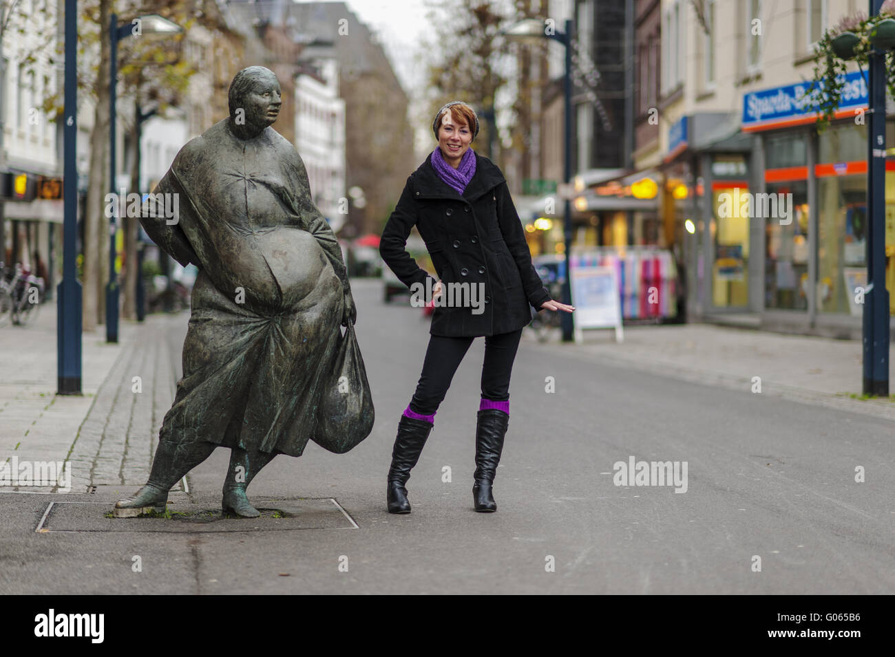 young woman and bronze figure in the pedestrian zo Stock Photo