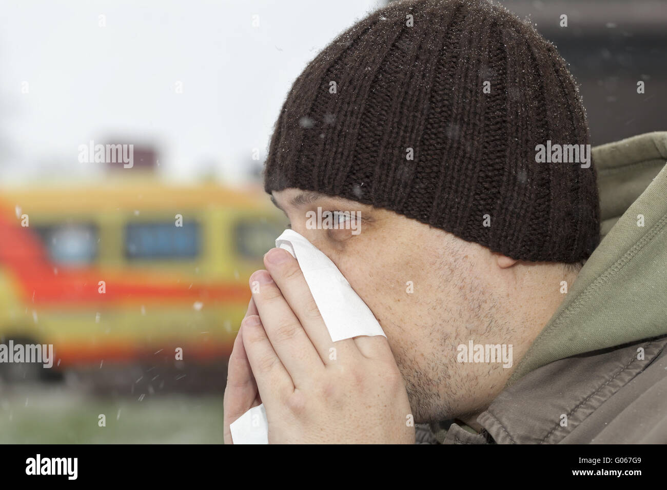 Man with a runny nose and napkin in hands near ho Stock Photo