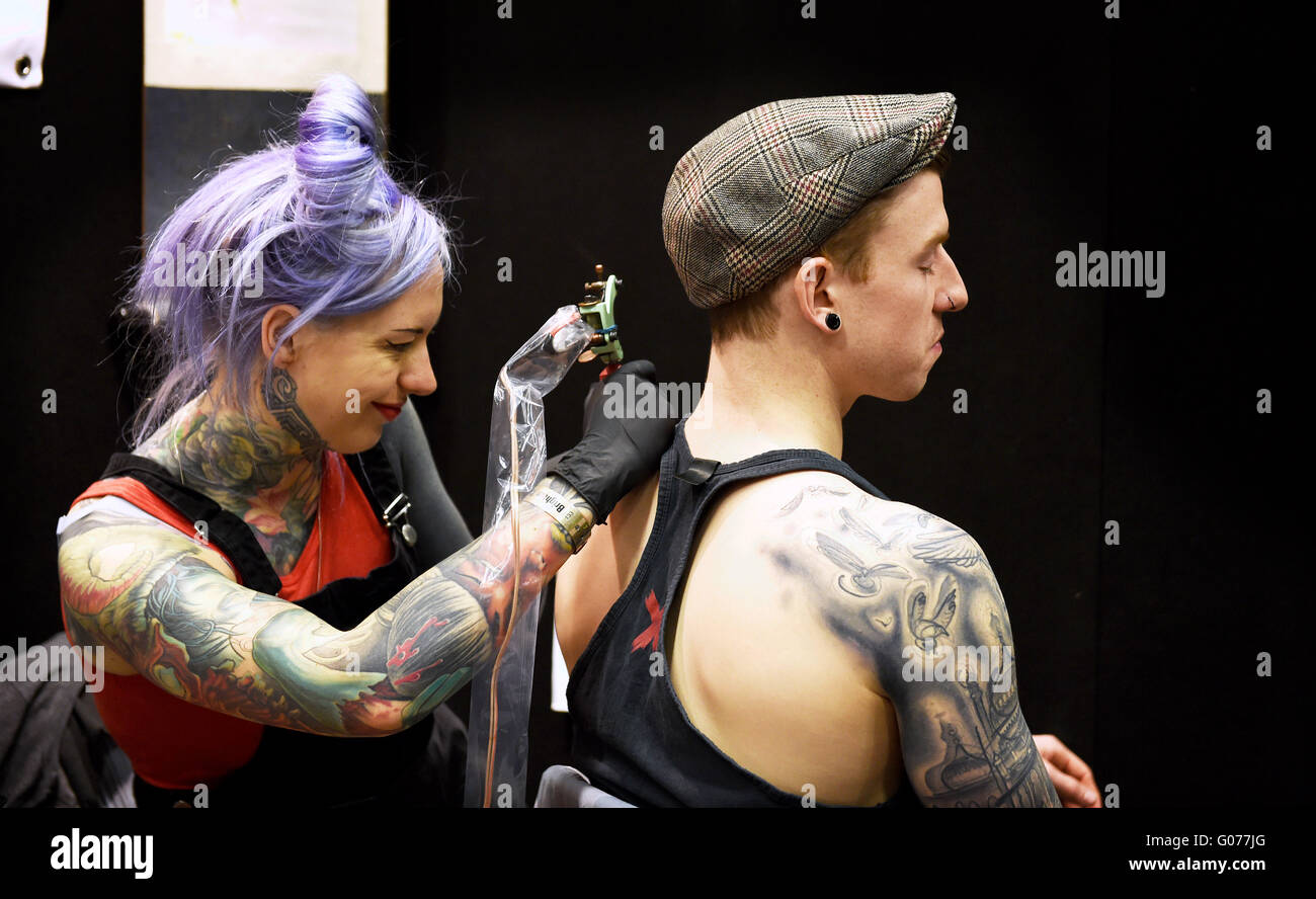 Brighton UK 30th April 2016 - Tattoo artist Hannah Keels at work at the 9th  Annual Brighton Tattoo Convention held in the Brighton Centre this weekend  © Simon Dack/Alamy Live News Credit: