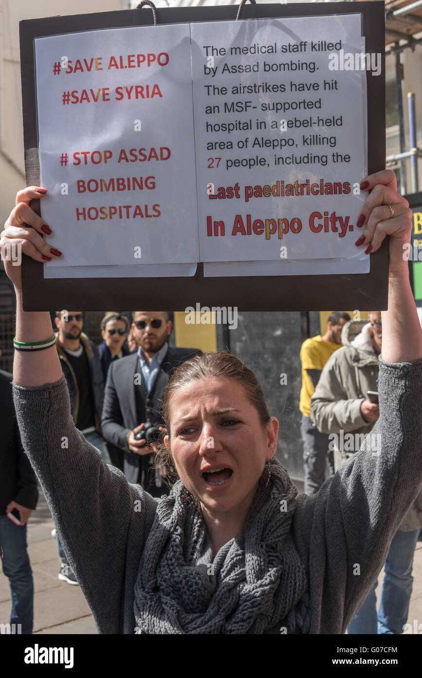 London, UK. 30th April, 2016. Protesters close to the Russian Embassy were calling for an end to Russian and Syrian air strikes on Aleppo after a raid on the Al-Qudus hospital there last Wednesday night killed tens of civilians including children and three doctors.  A woman shouts and holds up a detailed poster about the bombing of hospitals in Aleppo City, killing 27 people including the last paediatricians in Aleppo City. Peter Marshall/Alamy Live News Stock Photo