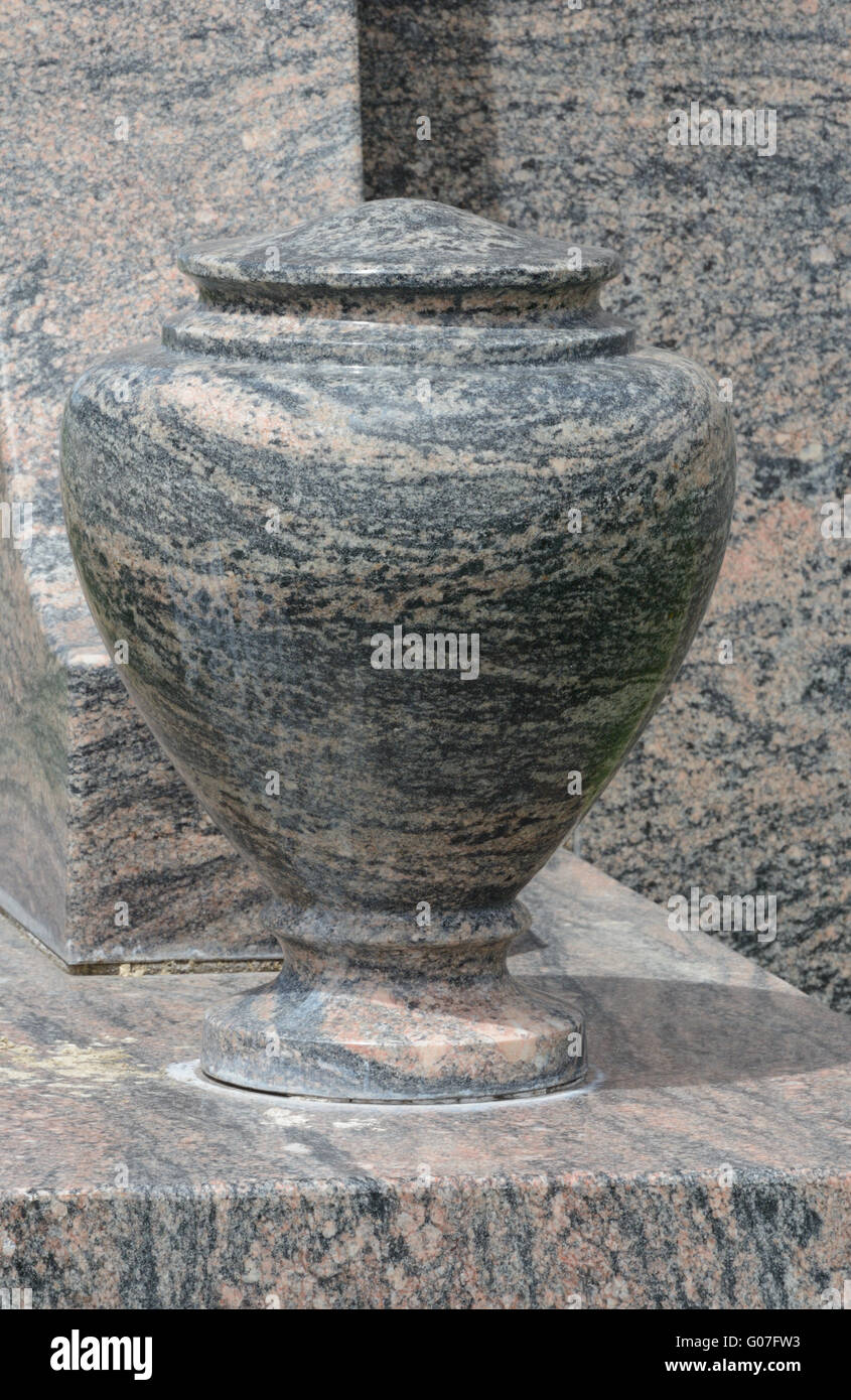 Empty marble flower vase next to gravestone Stock Photo