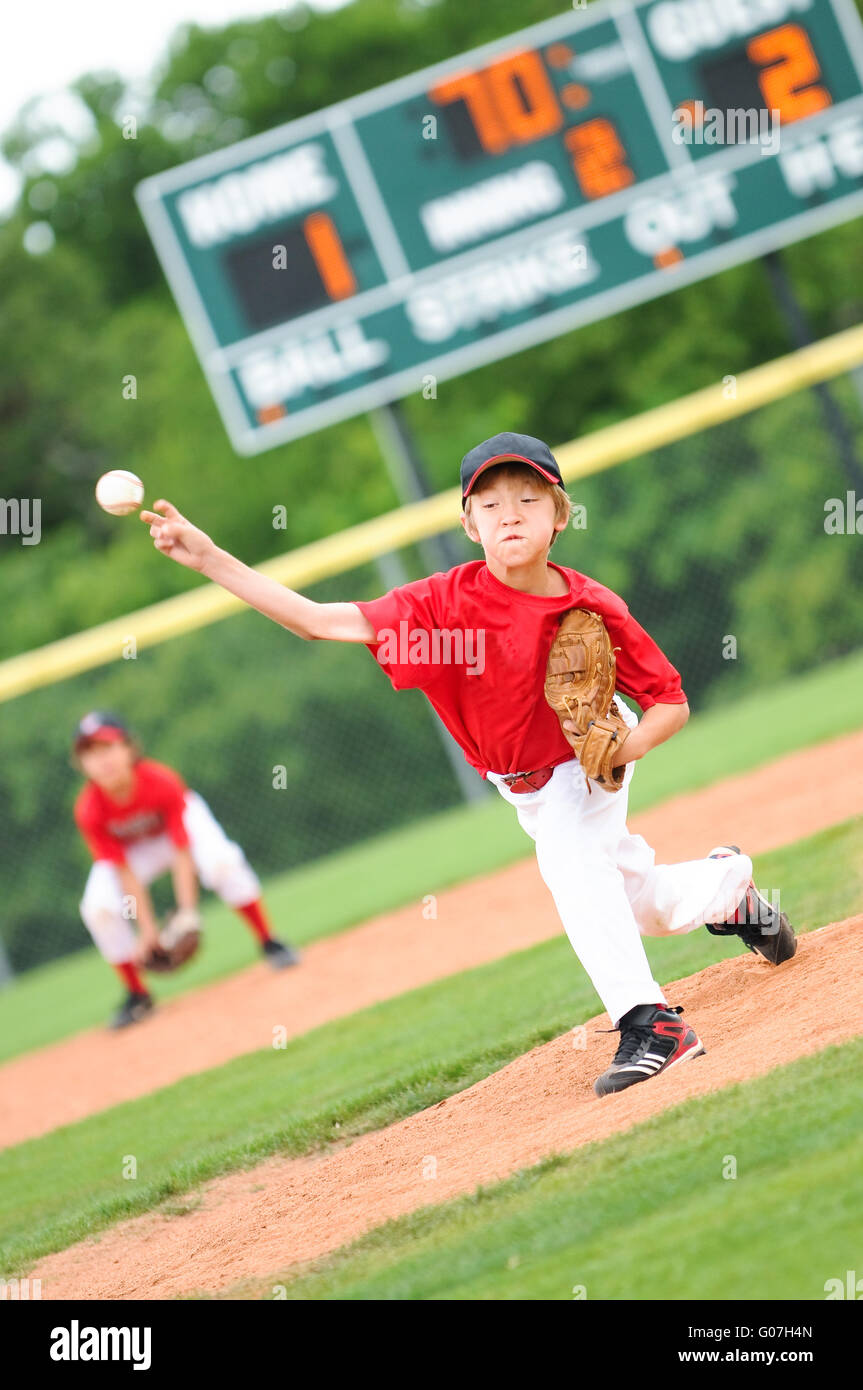 Young baseball player pitching the ball Stock Photo
