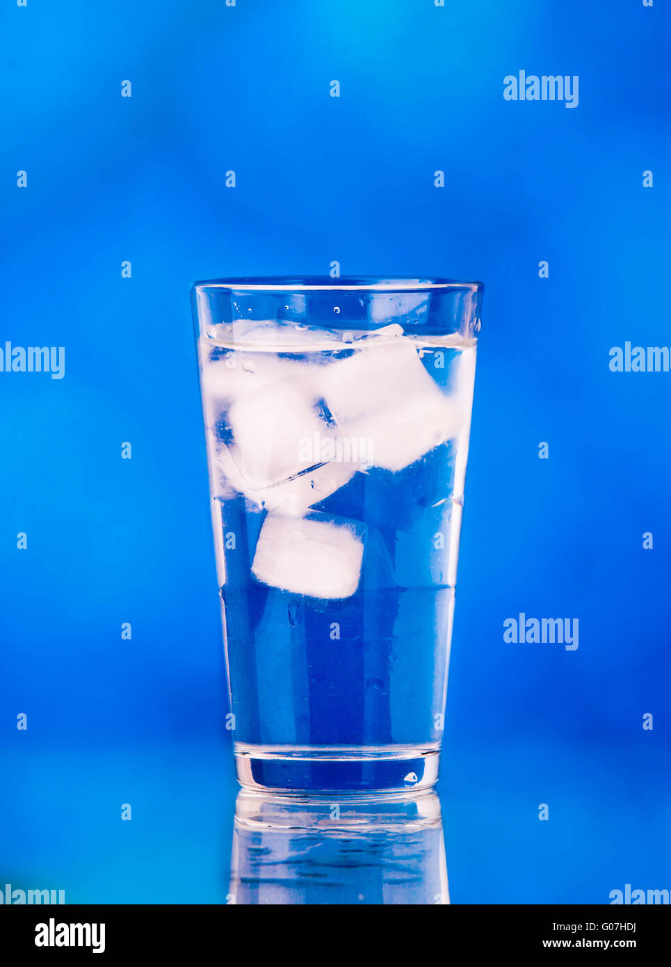 Glass of water on blue background. water with ice Stock Photo - Alamy