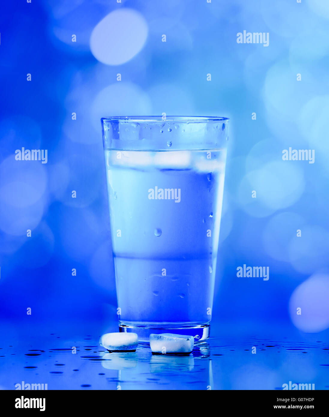 Glass of water on blue background. water with ice Stock Photo - Alamy