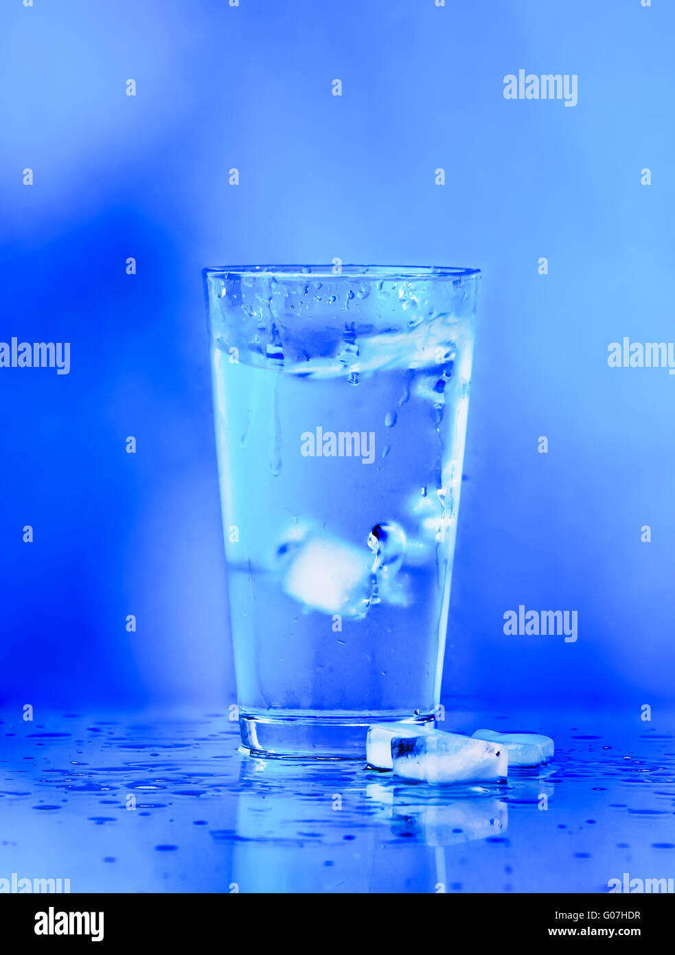 Glass of water on blue background. water with ice Stock Photo - Alamy
