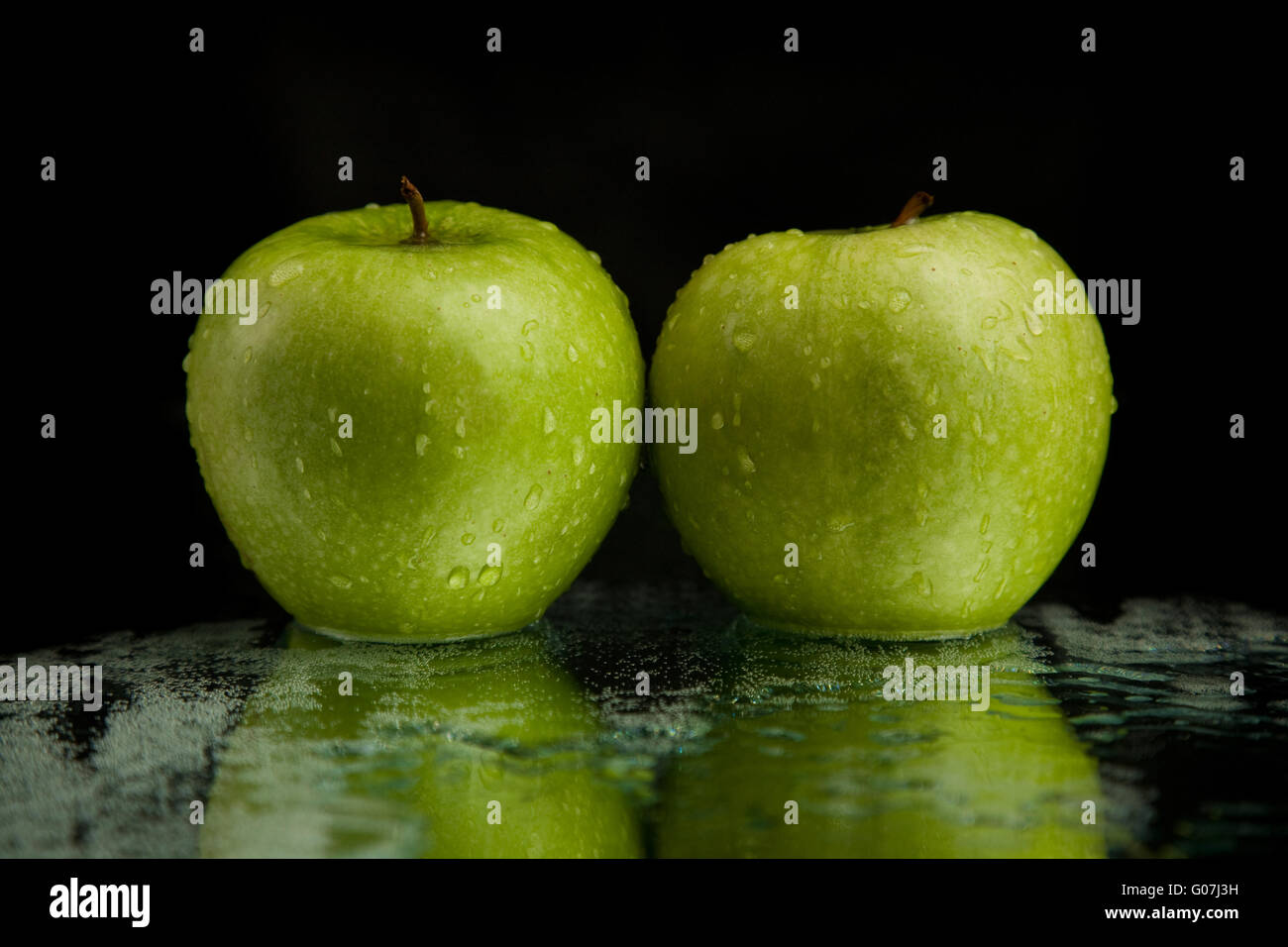 two green apples on mirror Stock Photo