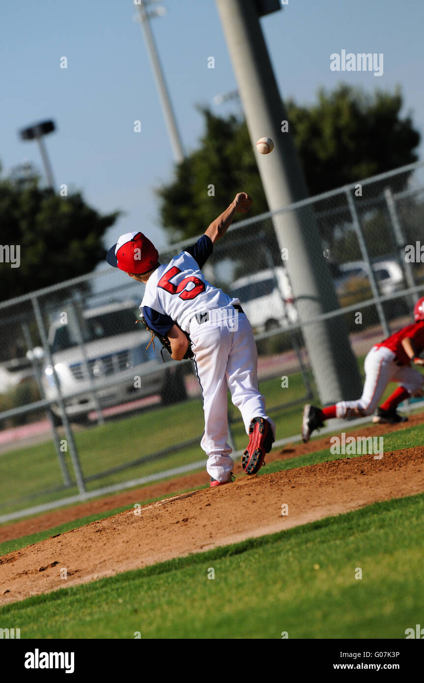 Little league pitcher throwing to first Stock Photo