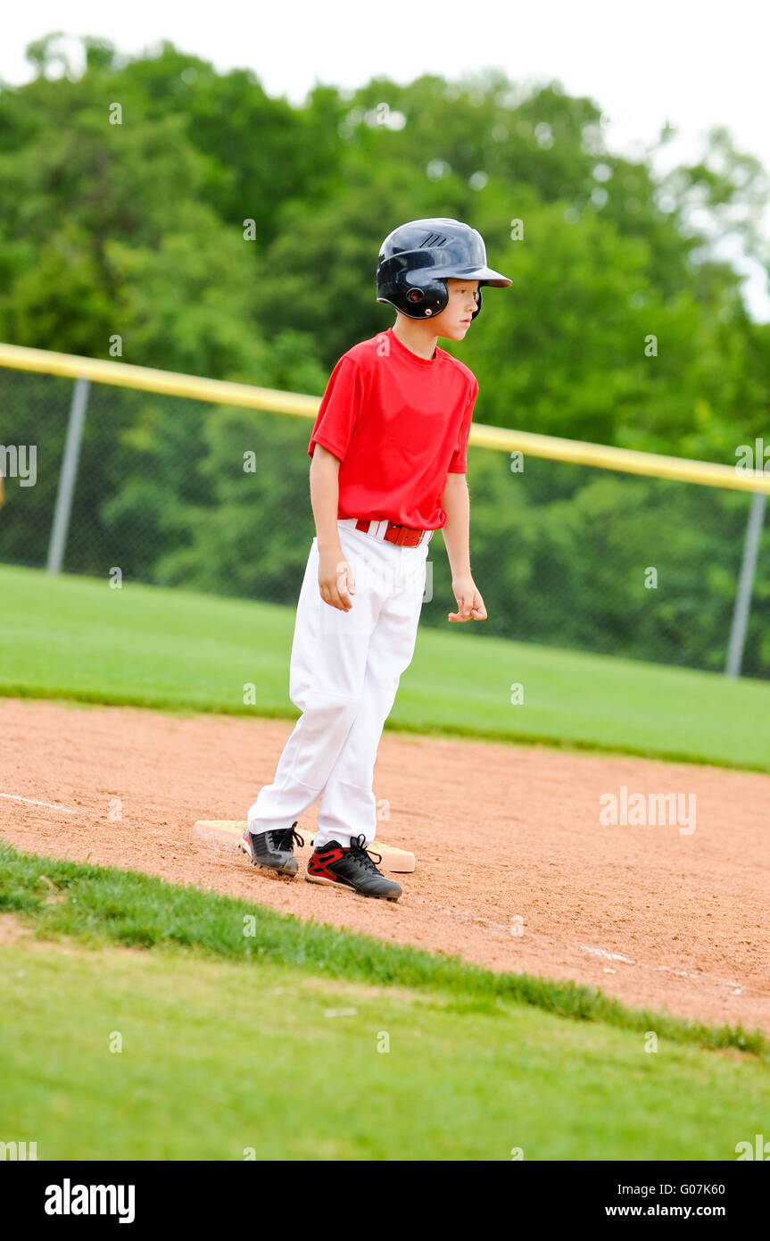 Youth baseball player on third base Stock Photo
