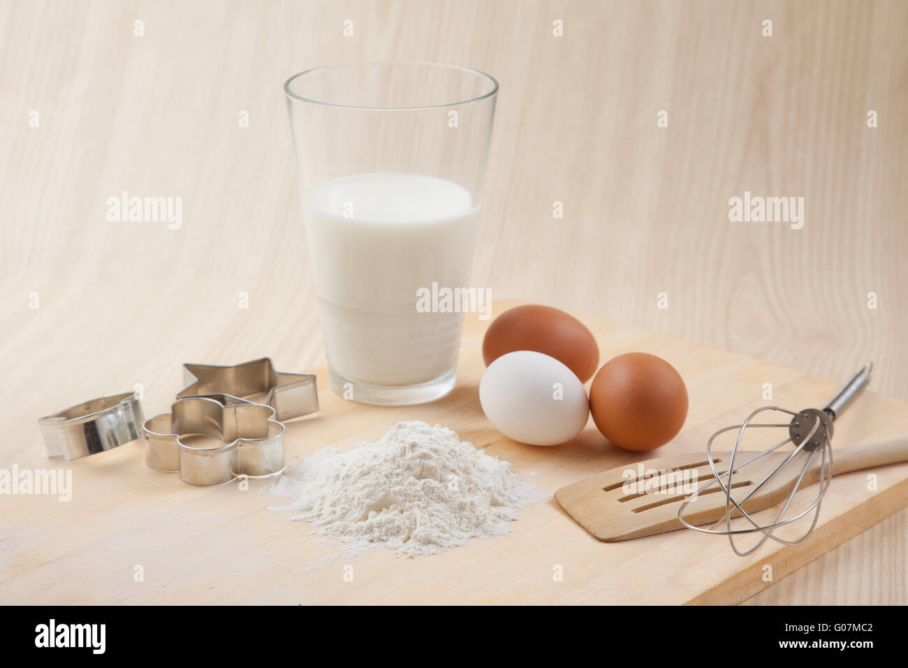 glass of milk, whisk, Cookie cutter forms and eggs Stock Photo