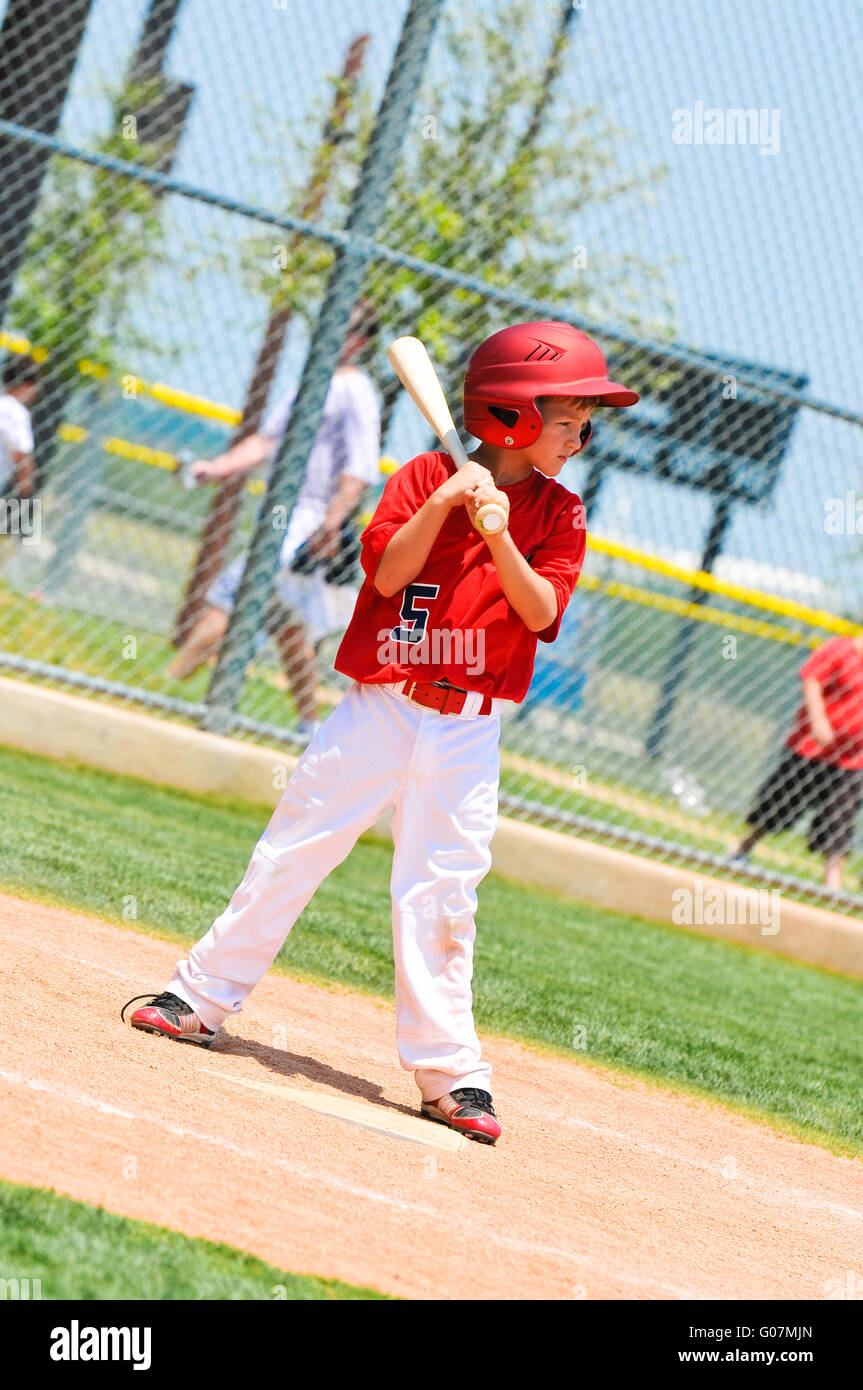 Youth baseball player with wood bat. Stock Photo