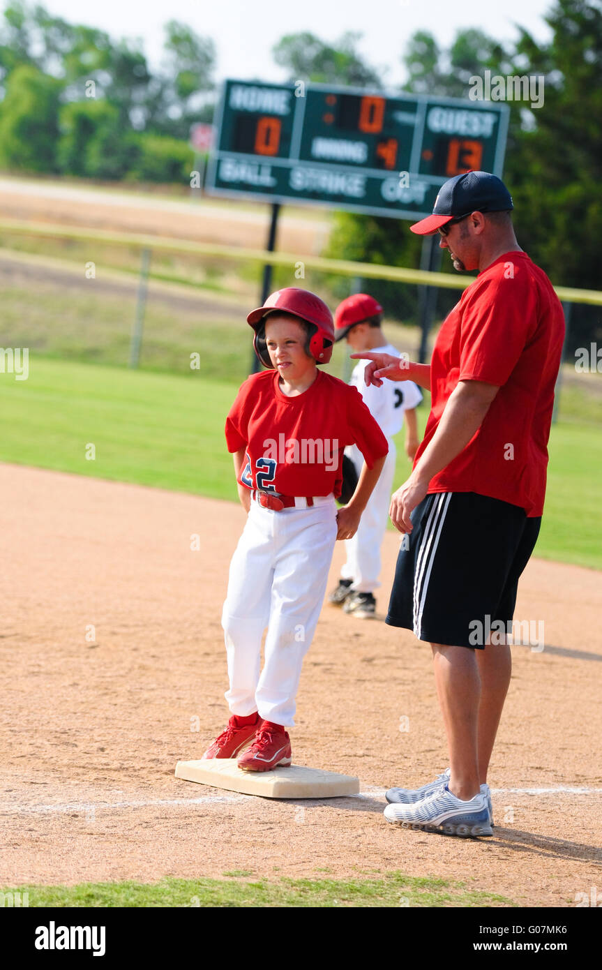 Baseball player and baseball coach at first base Stock Photo Alamy