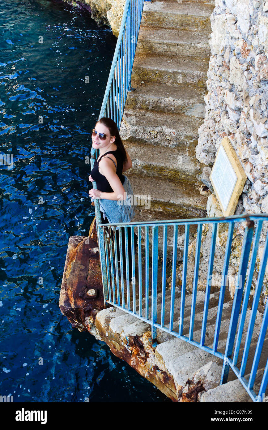 Brunette Woman Standing At A Blue Railing And Smiling Stock Photo - Alamy