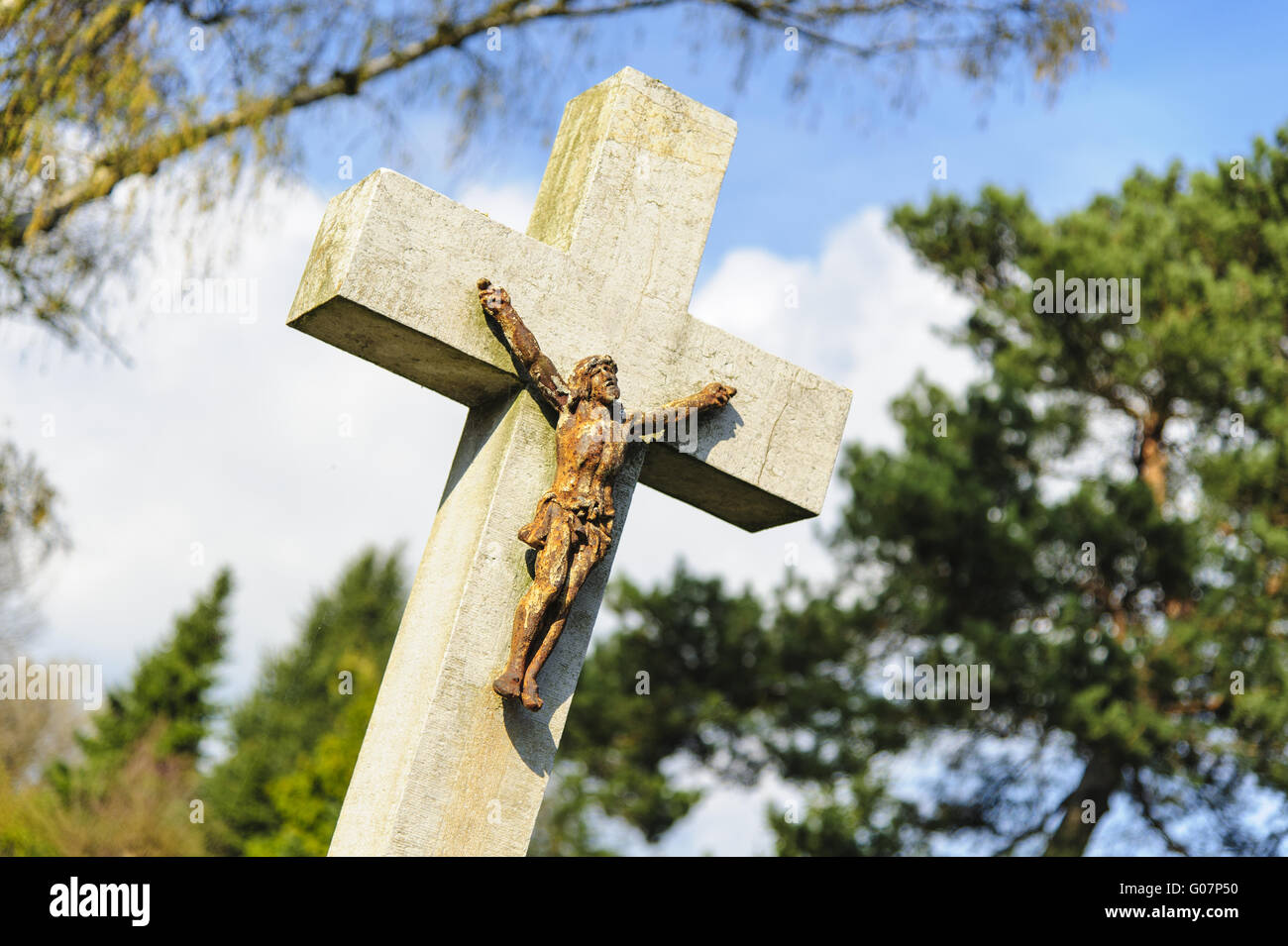 obliquely standing grave cross with Jesus figurine Stock Photo