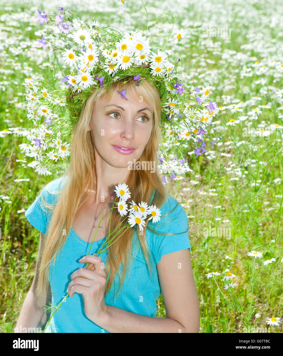 woman in a wreath from wild flowers in the field Stock Photo