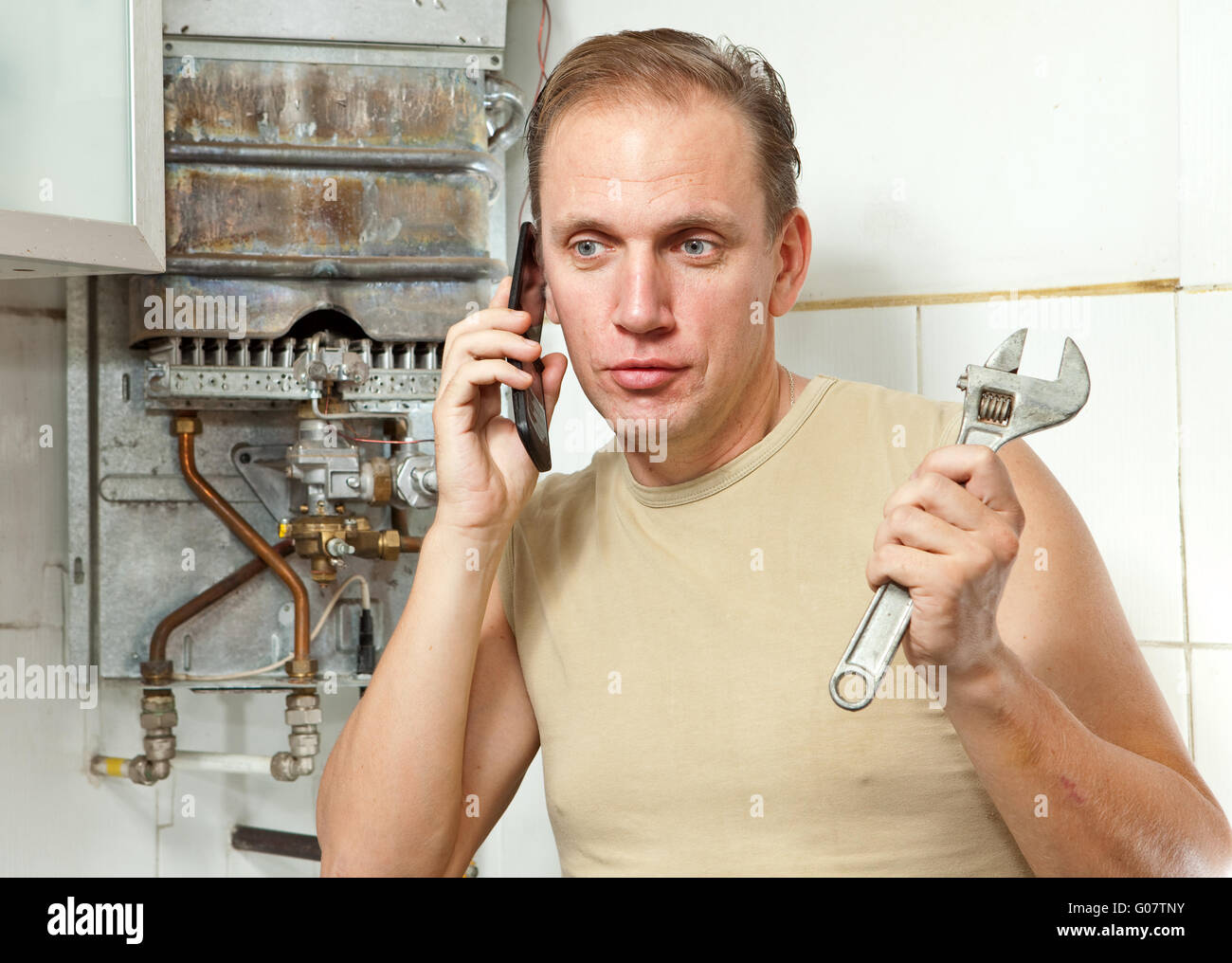 The man calls by phone to cause the repairman Stock Photo