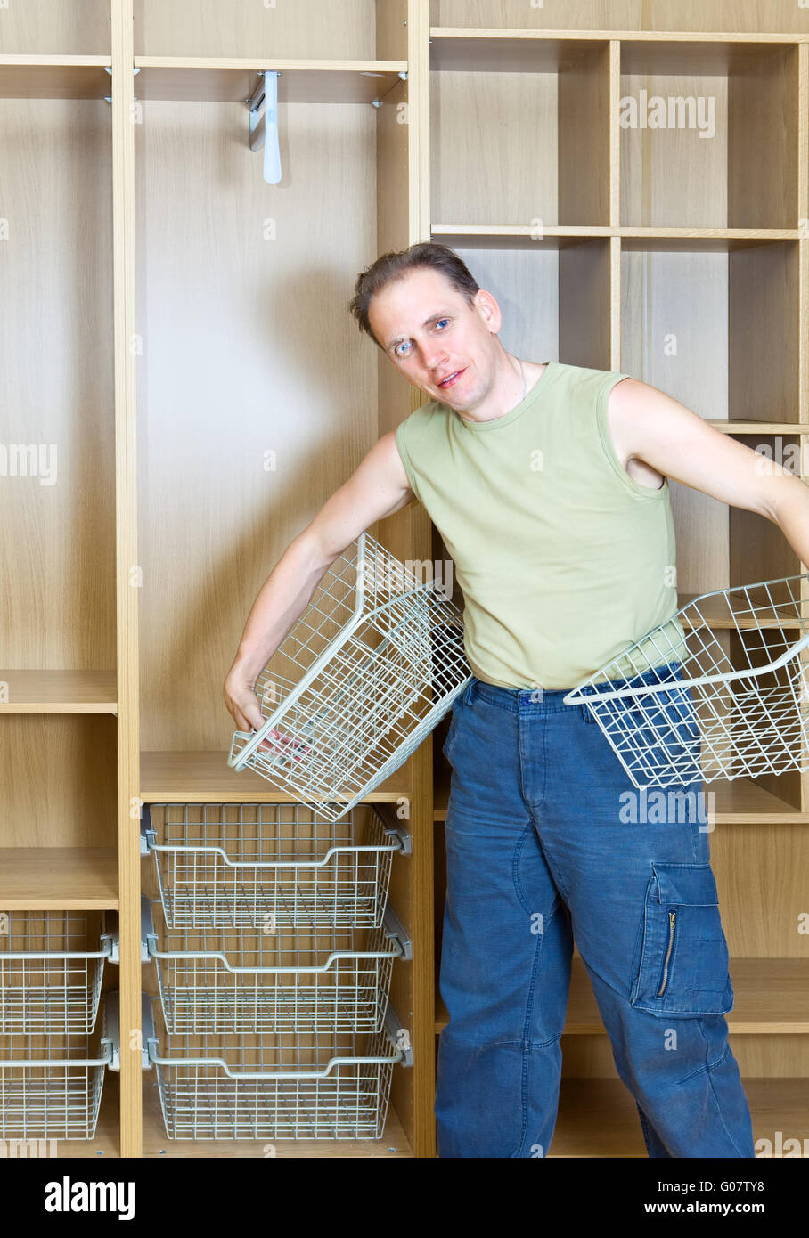 The man establishes baskets in a new wardrobe Stock Photo Alamy