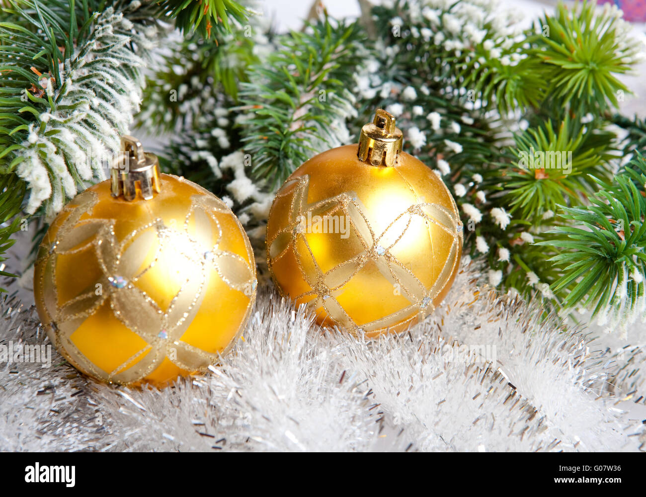 Two yellow New Year's balls and snow-covered branc Stock Photo