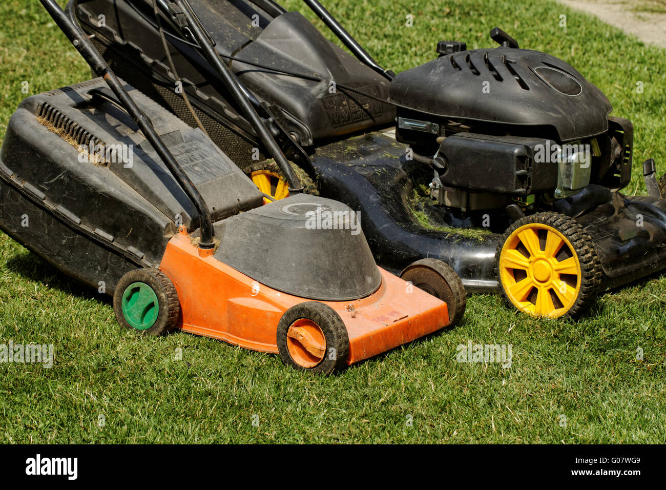 two lawnmower in the garden lawn the grass (fuel and electricity Stock