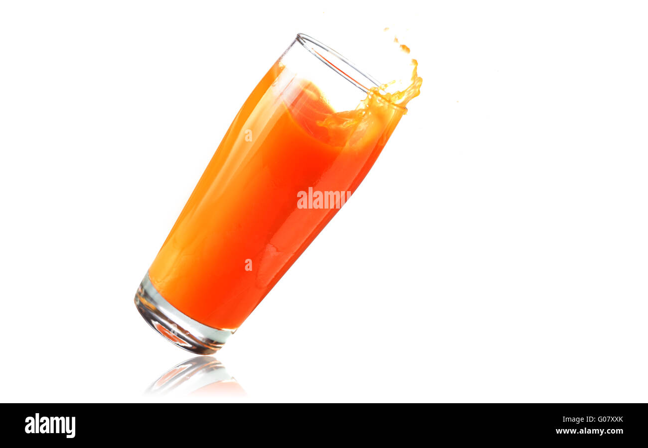 Big glass of orange juice falling over Stock Photo