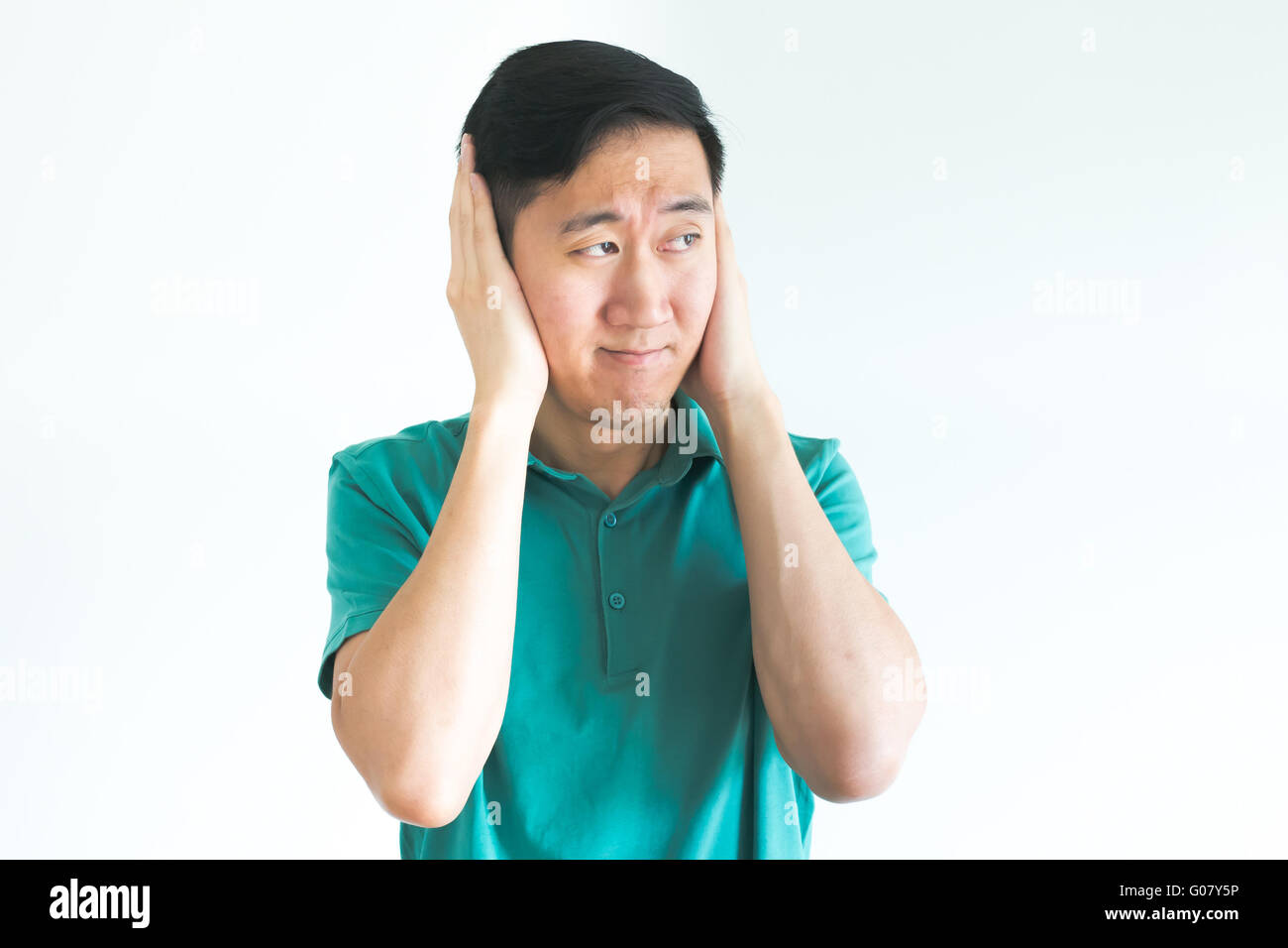 Stressed man covering his ears and do not want to hear, noise too loud Stock Photo