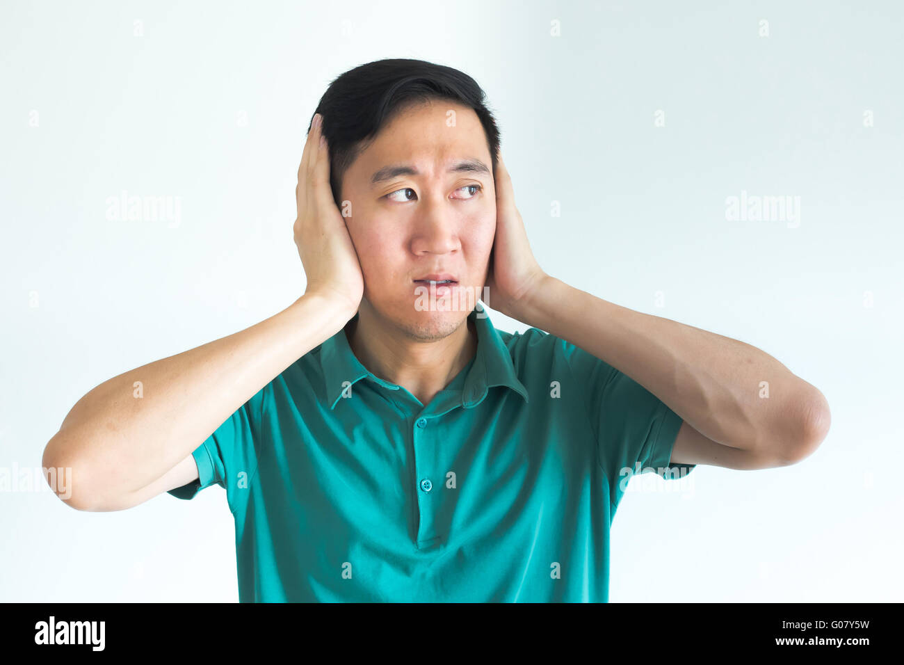 Stressed man covering his ears and do not want to hear, noise too loud Stock Photo