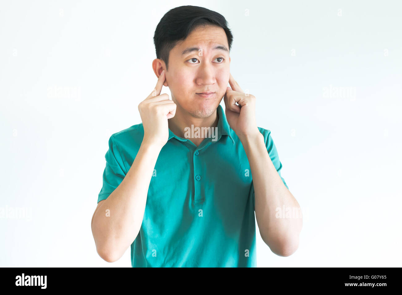 Stressed man covering his ears and do not want to hear, noise too loud Stock Photo