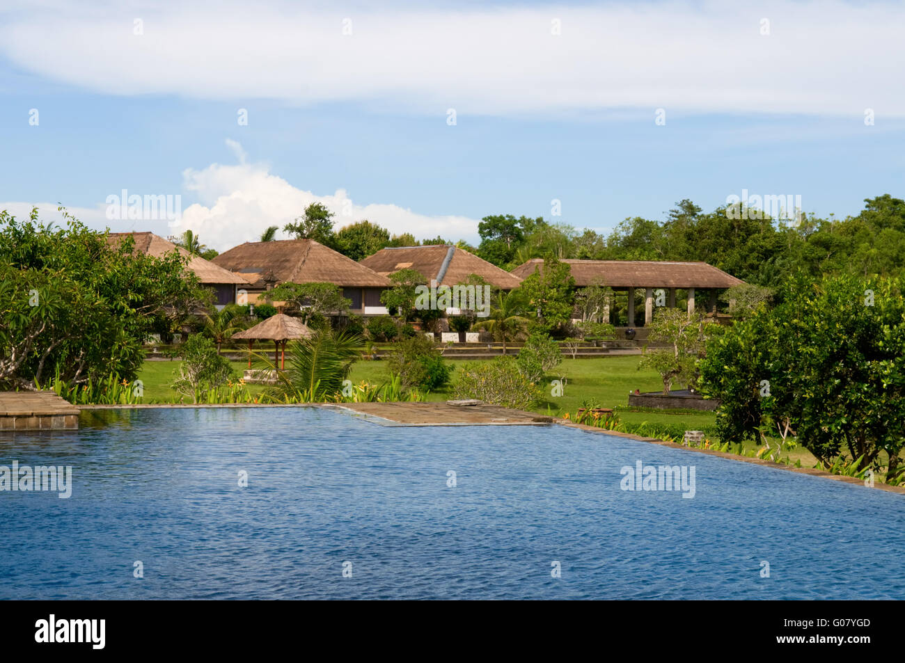 Villas and swimming pool in green field of India Stock Photo