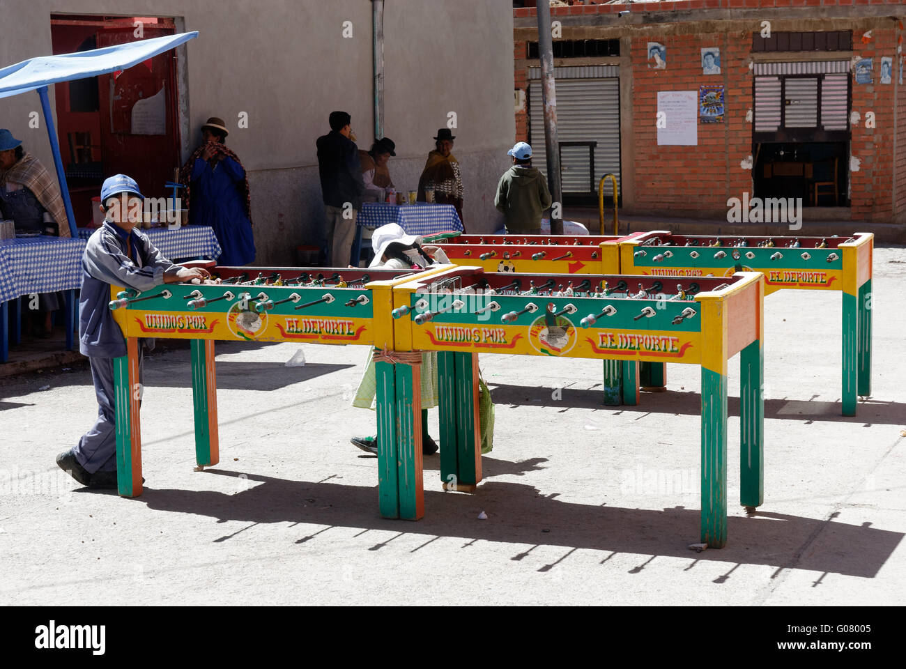 A boy waiting for an opponent at a table football game in the street in