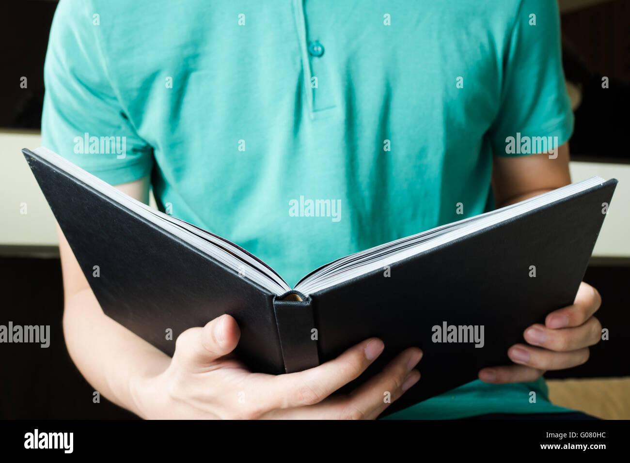Young man is reading a book while sitting on bed education and literature concept Stock Photo