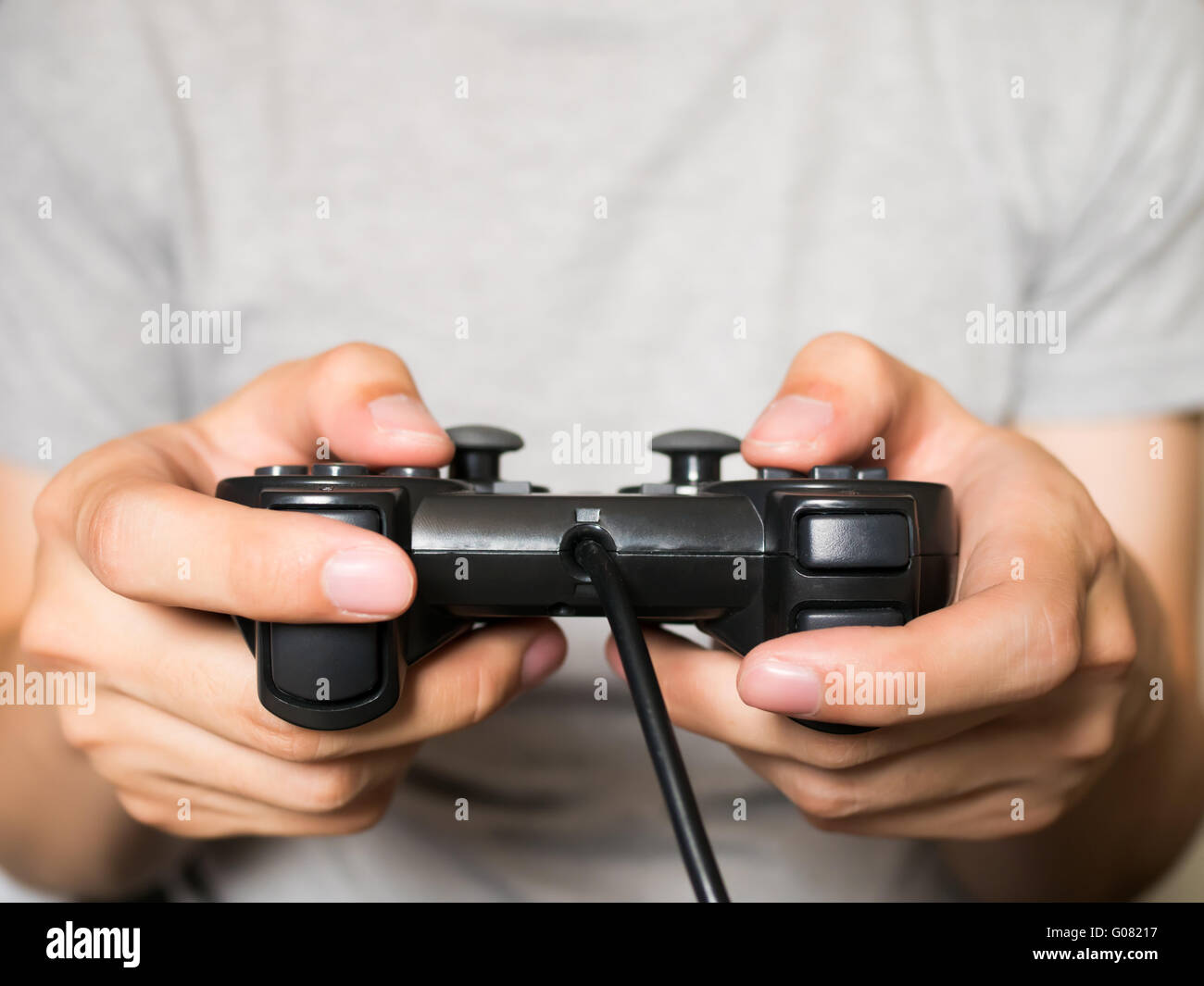 A young man holding game controller playing video games Stock Photo Alamy