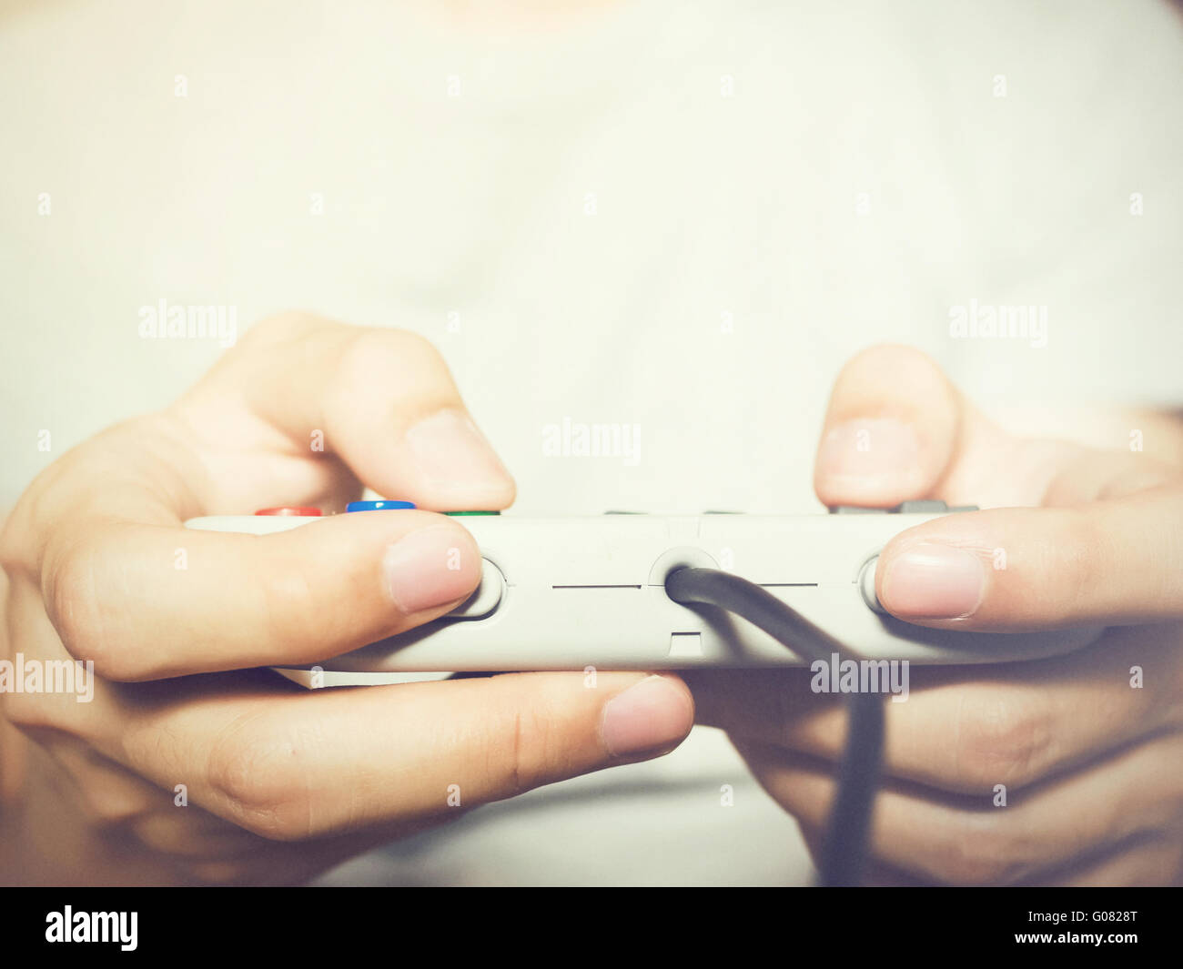 A young man holding game controller playing video games (vintage tone) Stock Photo