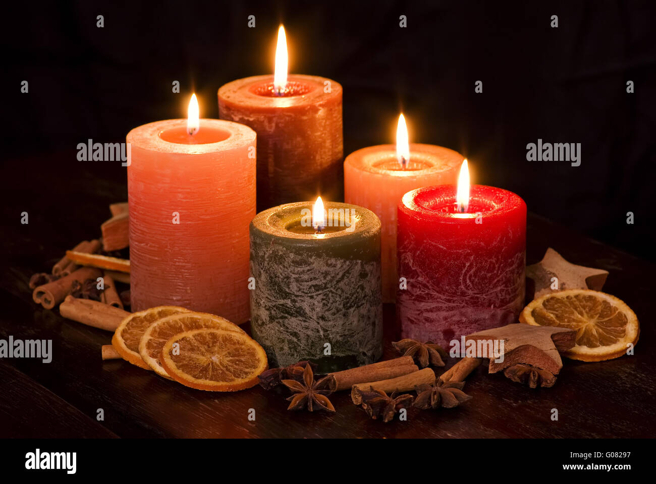 Colored Candlelight with decoration as closeup on a wood table Stock Photo