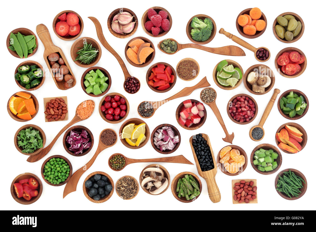 Health and super food of fruit, nuts, seeds and vegetables in wooden bowls and spoons over white