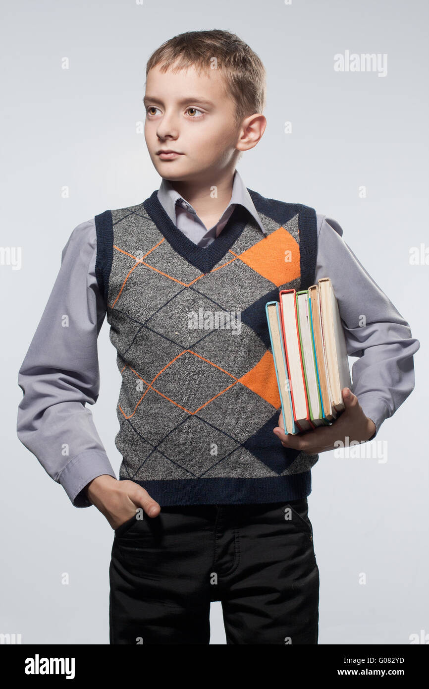 Little boy with books in hands. Looks aside. Stock Photo