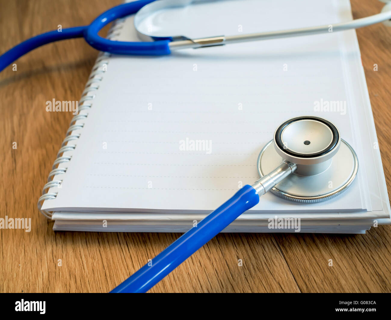 Stethoscope on empty notebook on wooden desk Stock Photo - Alamy