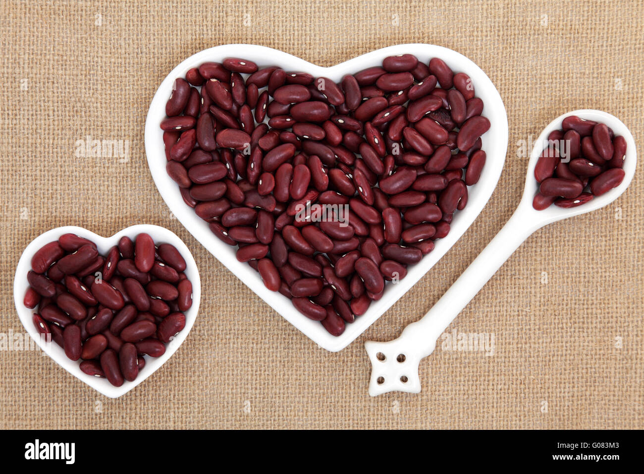 Kidney beans in heart shaped porcelain dishes and spoon forming an