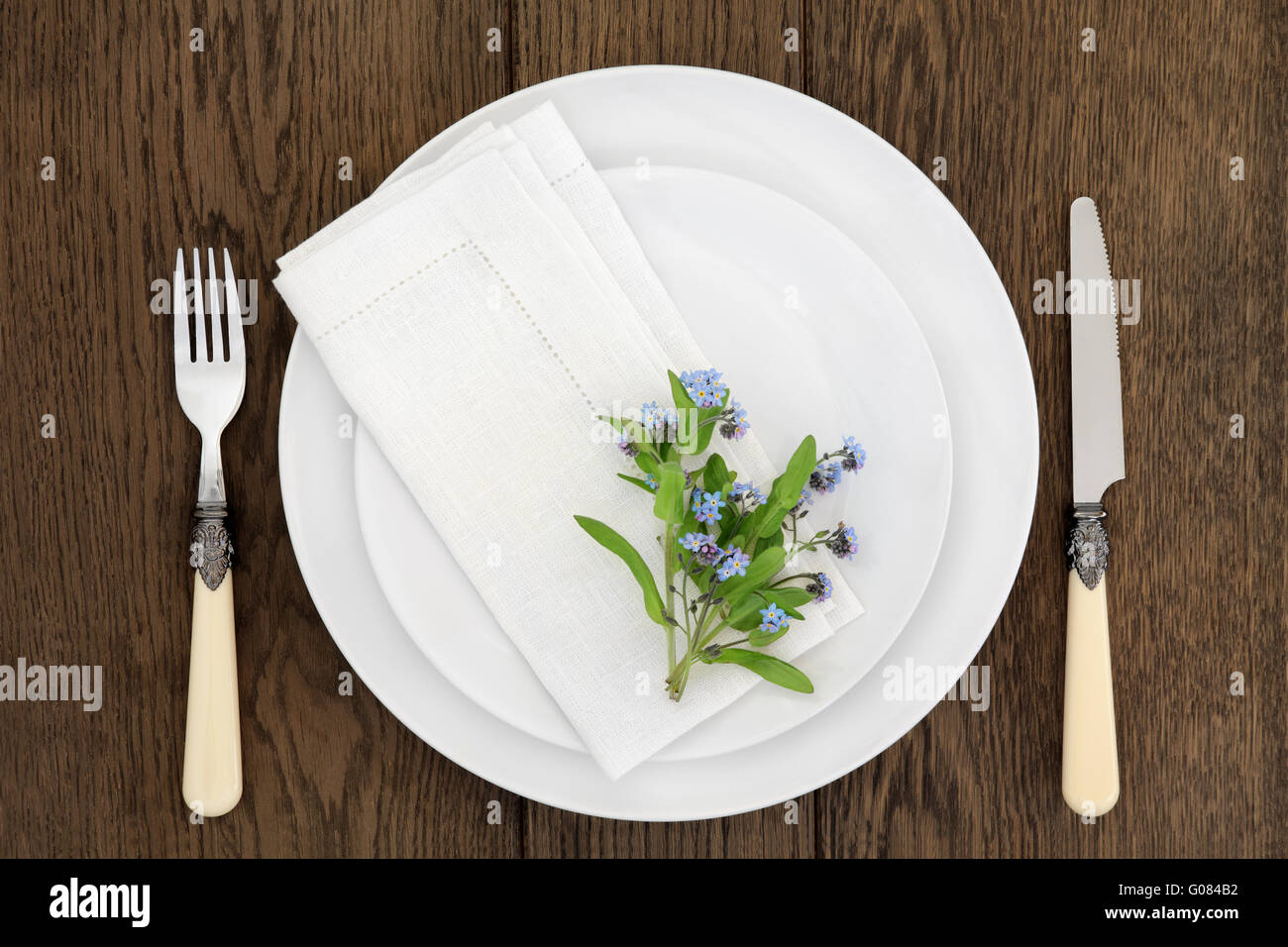 Dinner table place setting with forget me not flowers, white round ... Dinner table place setting with forget me not flowers, white round ...